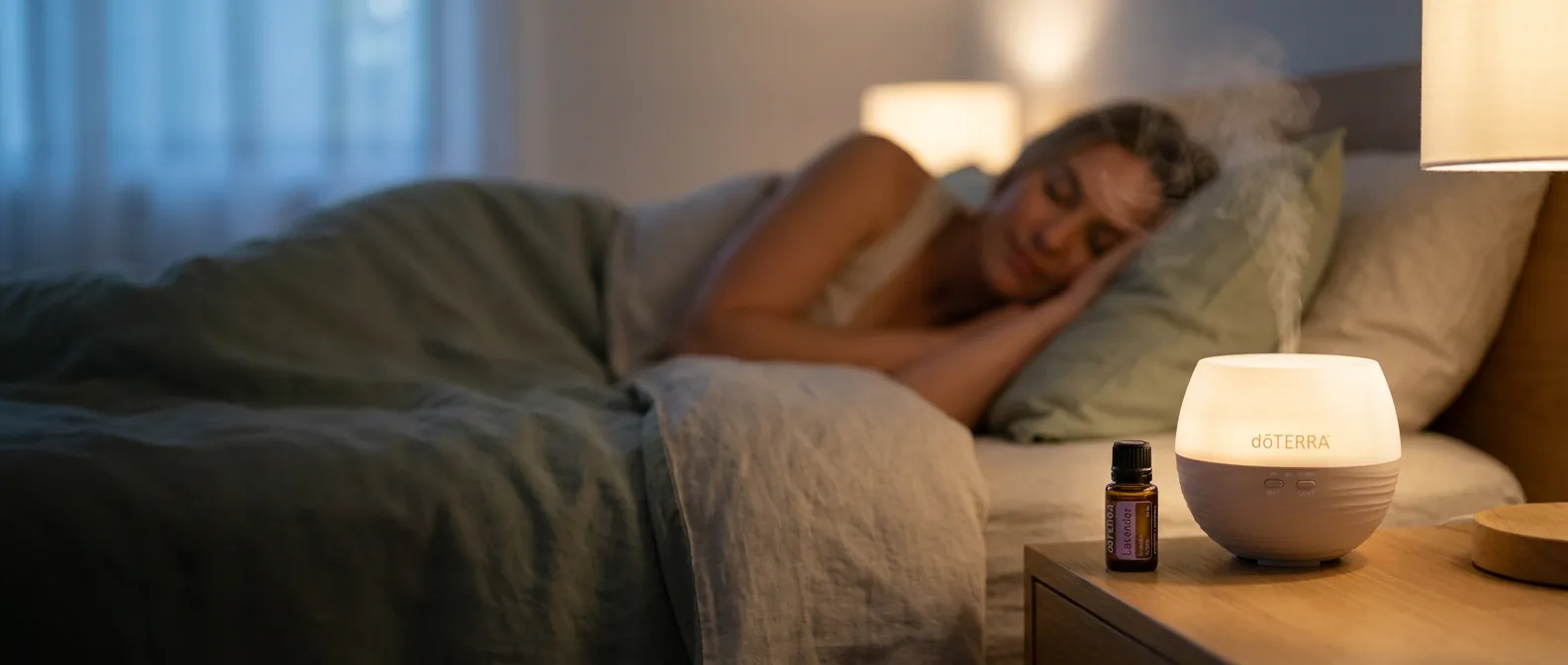 A woman sleeping peacefully beside a glowing dōTERRA Petal Diffuser and Lavender essential oil at night