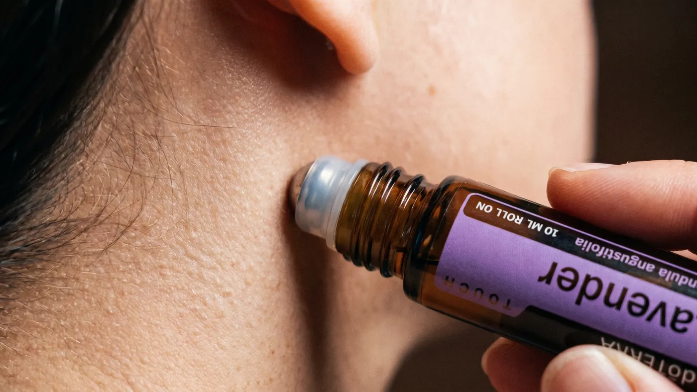 The dōTERRA Lavender Touch roll-on applied to the neck just behind the ear