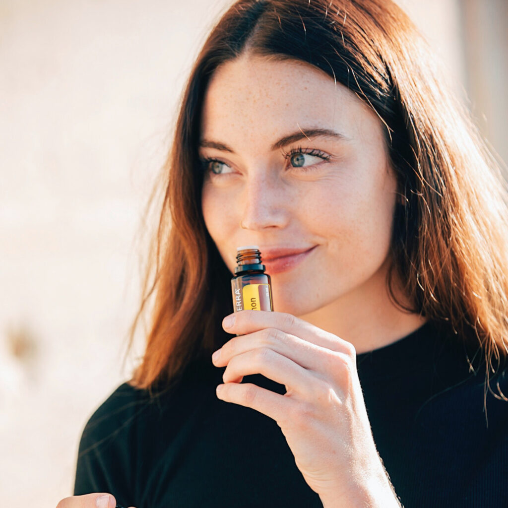 A woman enjoying the aroma of dōTERRA Single Essential Oils, highlighting their purity and natural benefits for wellness and aromatherapy.